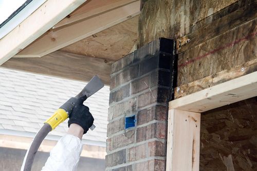 fire damage restoration technician restoring fire damaged exterior wall